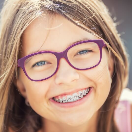 Preteen girl with traditional orthodontics