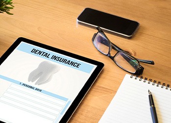 Dental insurance form on tablet on desk with notepad