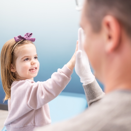 Child giving pediatric dentist a high five