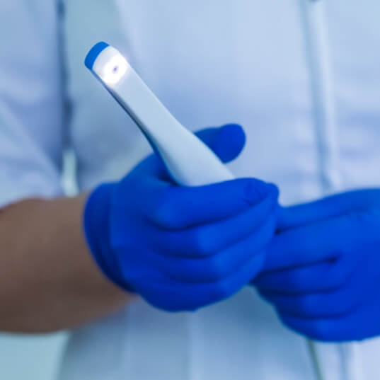 Pediatric dentist holding an intraoral camera