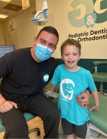 Pediatric dentist smiling with young child