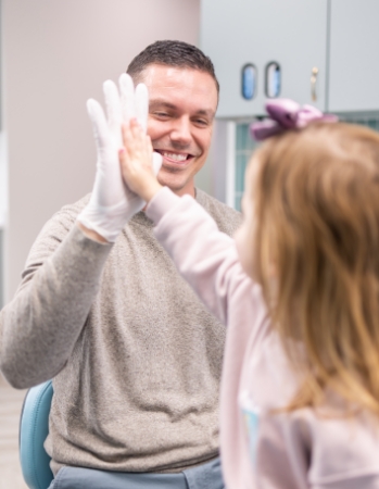 Pediatric dentist smiling with young child