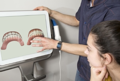 Pediatric dentist and dental patient looking at digital impressions on chairside computer screen