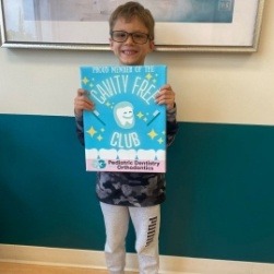 Dental team member and patient smiling with gift bag