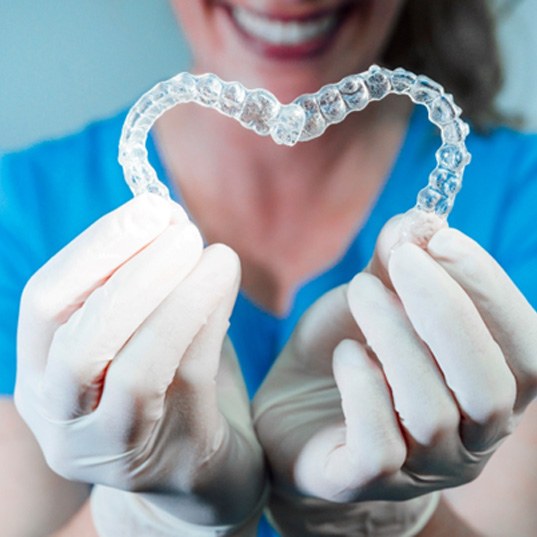 dentist making heart with Invisalign aligners 