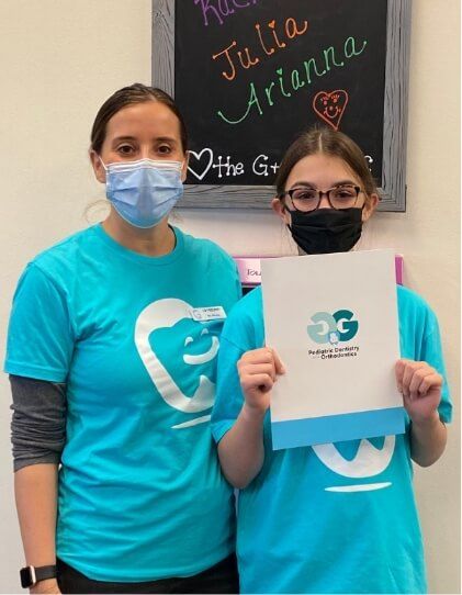 Orthodontist and young orthodontic patient smiling together