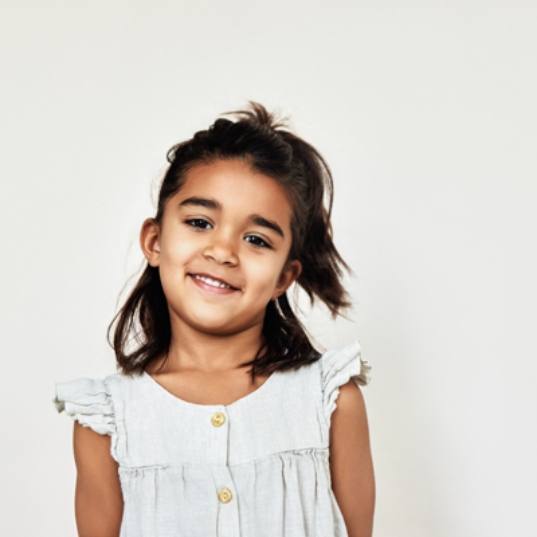 Child holding model smile during early orthodontic intervention