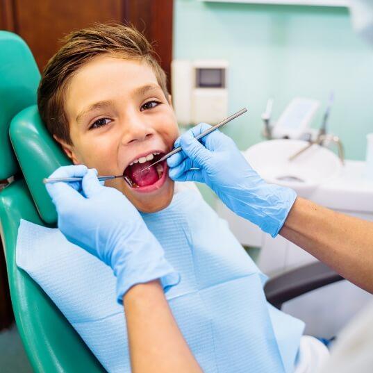 Child receiving exam during first pediatric dentistry visit
