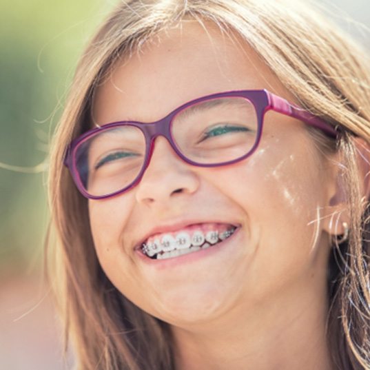 a girl grinning with traditional braces in Naperville