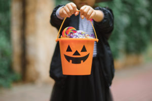 a child holding a Halloween bucket full of candy