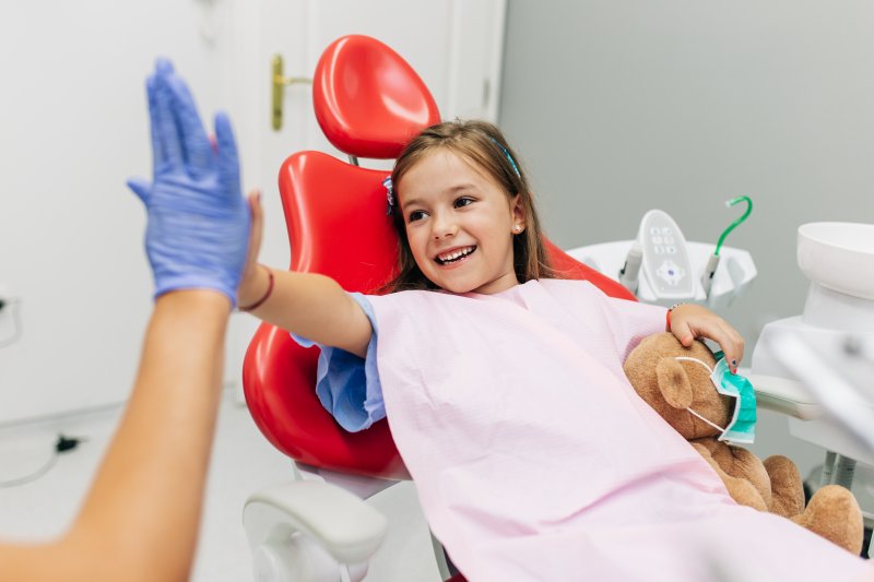 A child high-fiving her dentist at her pediatric dentistry appointment