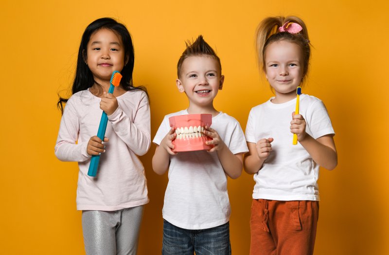 A group of kids holding dentist-themed toys