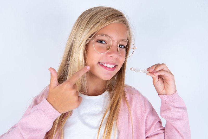 Young patient smiling with their Invisalign aligners