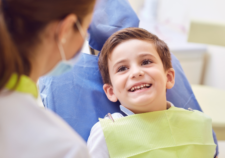 Child in dental chair, smiling